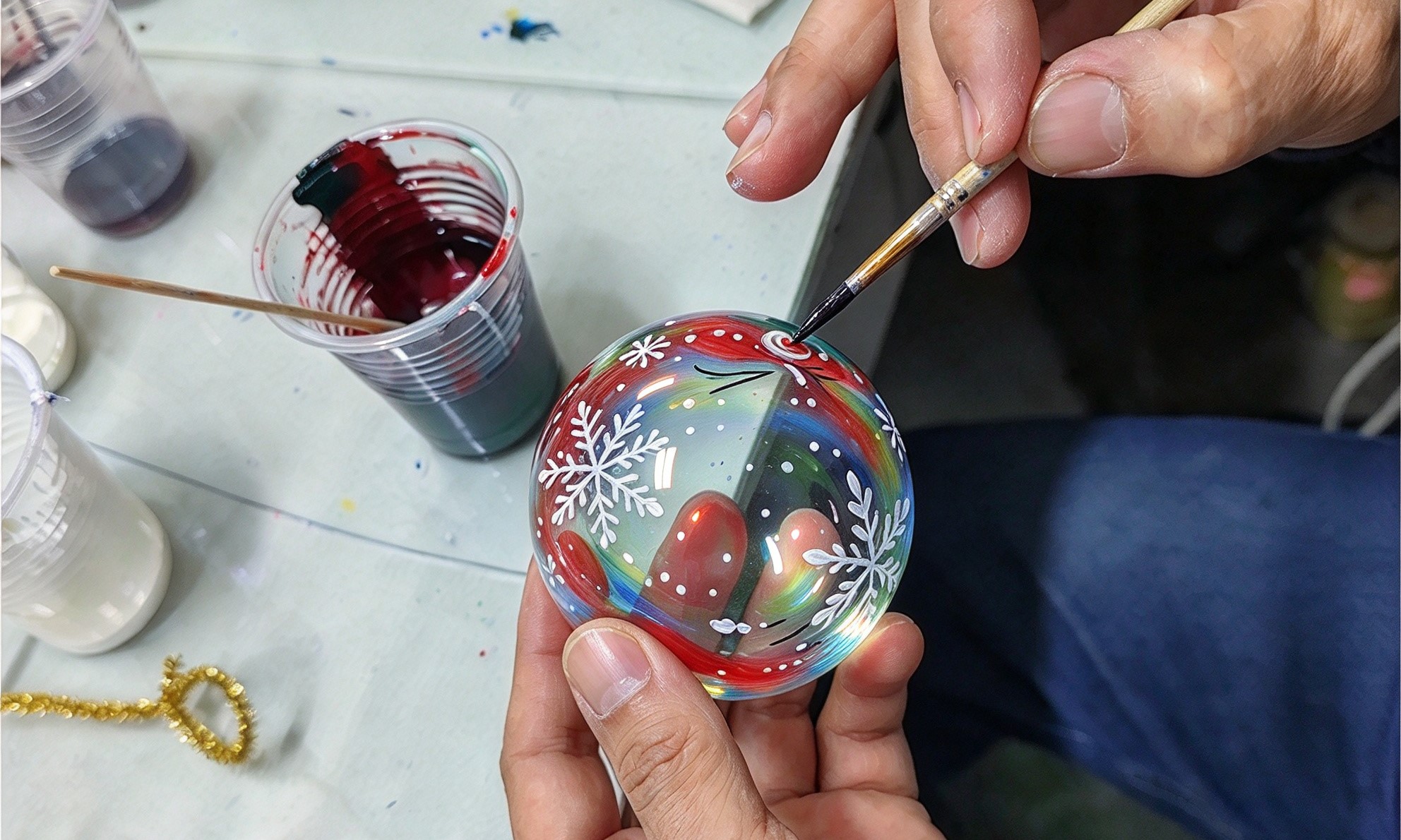 Hand painting decorative details on handmade glass Christmas balls